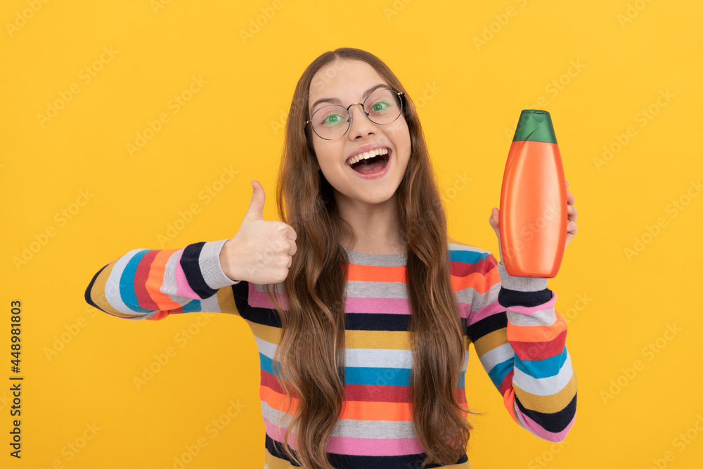 happy teen girl use shampoo bottle. child with hair conditioner. happy teen girl use shampoo bottle. child with hair conditioner.