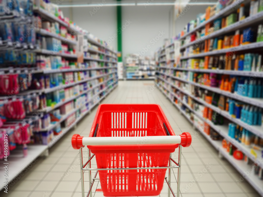 Supermarket shelf blurred trolley. Buy in the supermarket blurring the shelves with products Supermarket shelf blurred trolley. Buy in the supermarket blurring the shelves with products