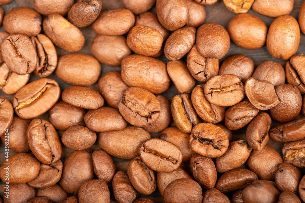 Roasted coffee beans scattered on the surface close-up, selective focus. Roasted coffee beans scattered on the surface close-up, selective focus.