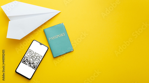 Qr code proof negative covid 19 PCR test for free travel summer vacation. Green passport certificate on smartphone screen airplane. Long web banner flat lay on yellow summer background with copy space
