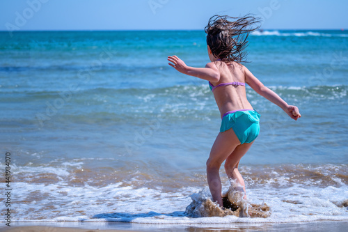 Young beautiful girl dancing in the sea.
