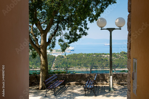 Beautiful panoramic seascape of Adriatic sea marina, yachts and old park bench of Omišalj town on Croatia island photo