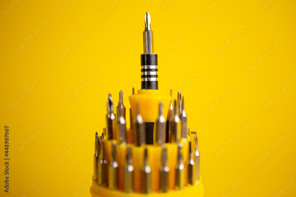 a set of screwdrivers for work on a yellow background a set of screwdrivers for work on a yellow background