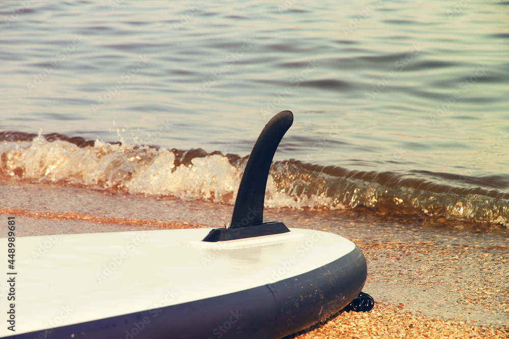 Fototapeta premium Keel of inverted SUP boat against the background of the sea surf
