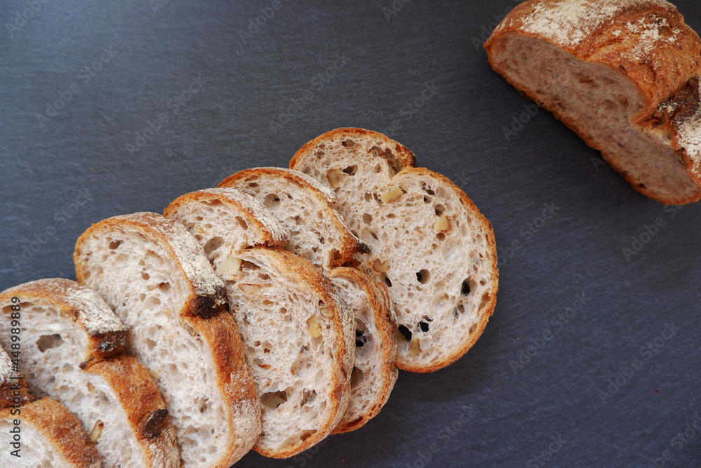 Close-up image of a bread cutting on a black background. Healthy baked bread, whole bread on dark background.
