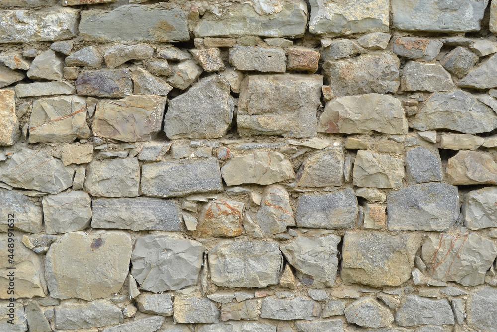 Texture of stone wall with mosaic tiles.