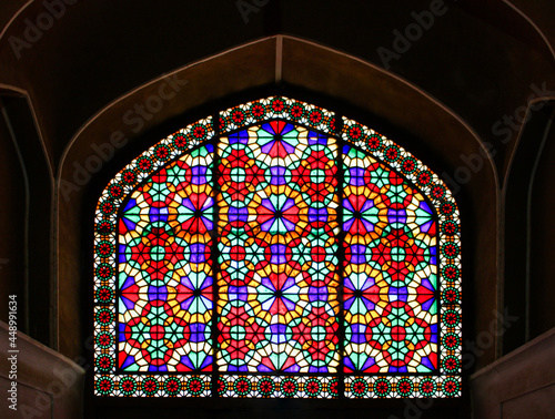 the colorful symmetric stained glass window of Iranian historic architecture