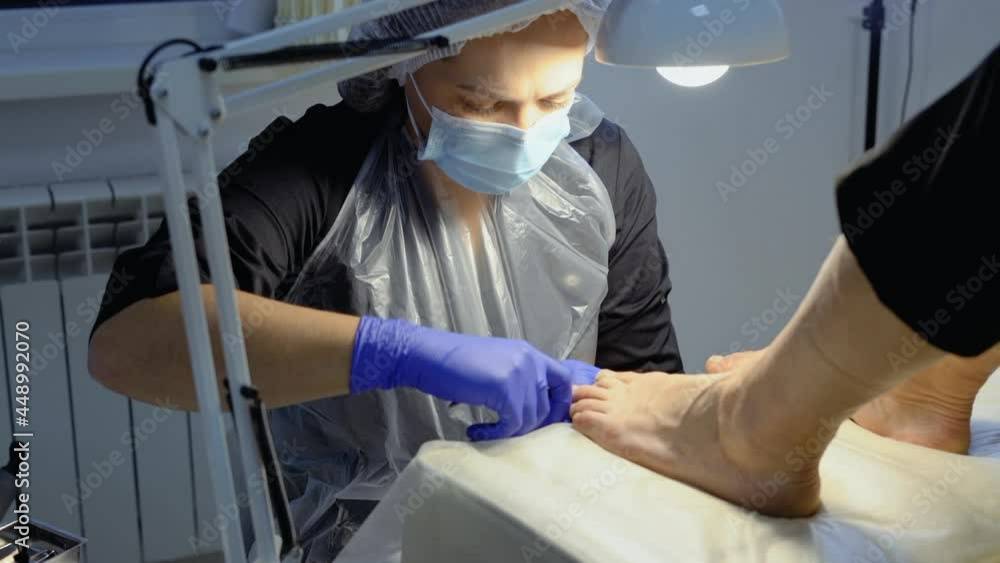 The podiatrist does a pedicure in the salon. Pedicure procedure with nail clipper tool The podiatrist does a pedicure in the salon. Pedicure procedure with nail clipper tool