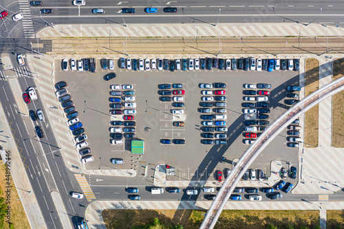 Aerial drone view of a parking lot with many cars near supermarket.