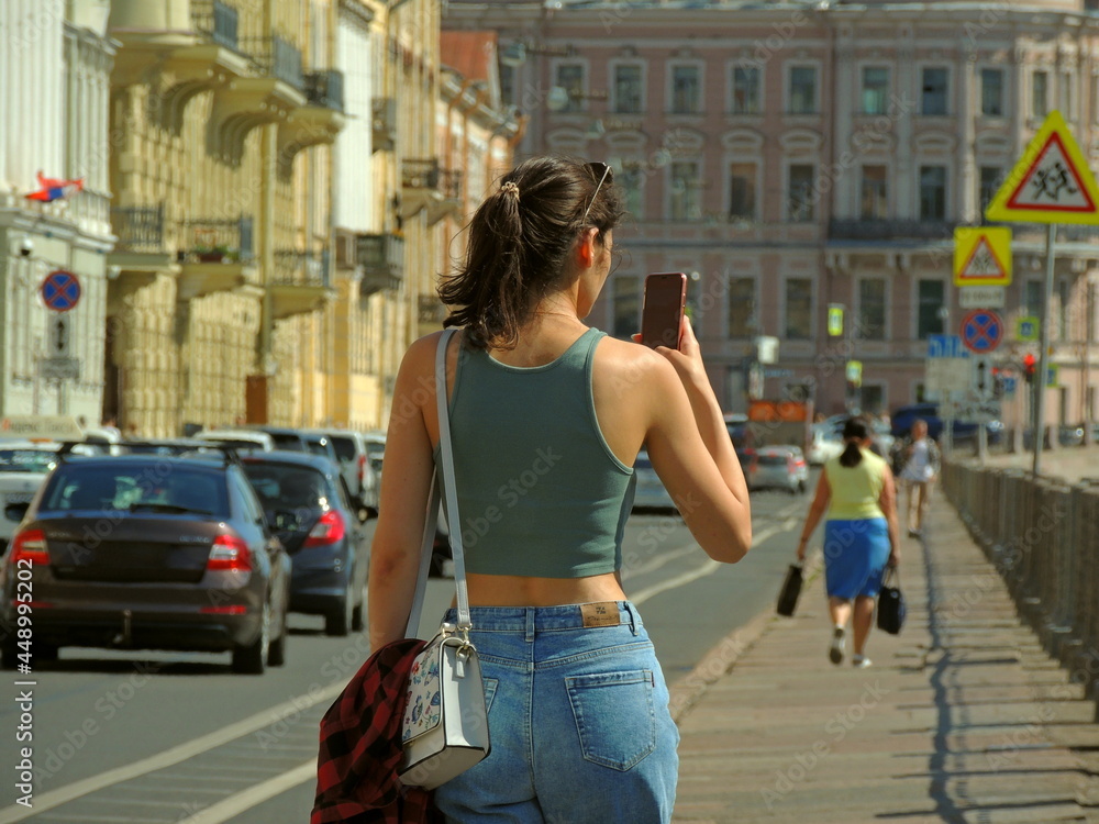 A girl of Caucasian appearance with a phone in her hands. Shooting and spending time on social networks.