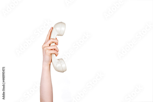 Hand holding vintage beige telephone handset on white background isolated. Telephone communication items and icon. Concept of hands and body parts.