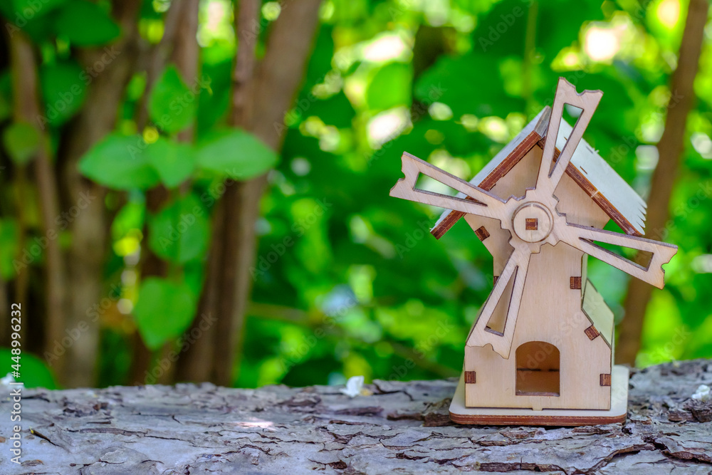 toy mill on a log with greenery background toy mill on a log with greenery background