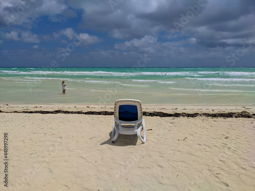 Cayo Coco, Cuba, May 16, 2021: sandy beach of the hotel Tryp Cayo Coco with sun loungers and azure ocean waters. People swim, sunbathe and relax near the ocean. photo
