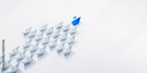 Arrow shaped group of paper boats with blue leader going in same direction - 3D illustration