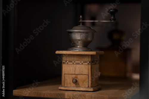 The coffee grinder is on the shelf. Wooden coffee grinder