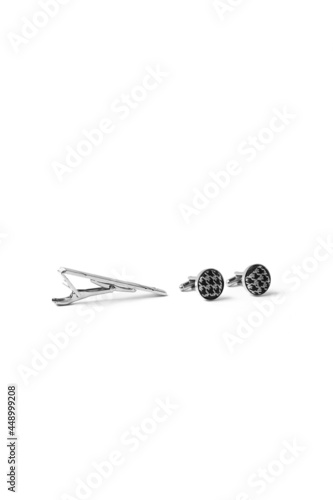 Subject shot of steel tieclip and cufflinks with textile surface with houndstooth design. Stylish accessories for office wear are isolated on the white background. photo