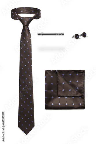 Subject shot of stylish set for office wear composed of brown tie with geometric design, silk handkerchief to match, steel tieclip and cufflinks. Accessories are isolated on the white background. photo