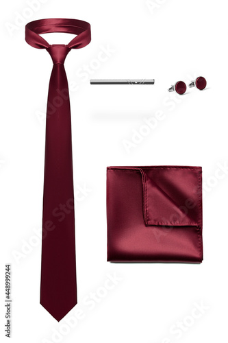 Subject shot of stylish set for office wear composed of burgundy tie without pattern, silk handkerchief to match, steel tieclip and cufflinks. Accessories for men are isolated on the white background. photo