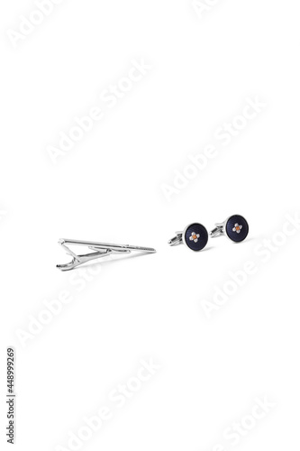 Subject shot of steel tieclip and cufflinks with textile surface with floral pattern. Stylish accessories for office wear are isolated on the white background. photo