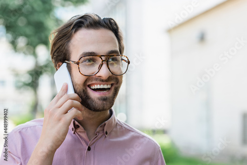 Cheerful businessman talking on mobile phone outdoors