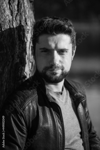 Black and white profile portrait of a serious bearded modern businessman in a stylish leather jacket. Stylish business casual style for men, portrait concept