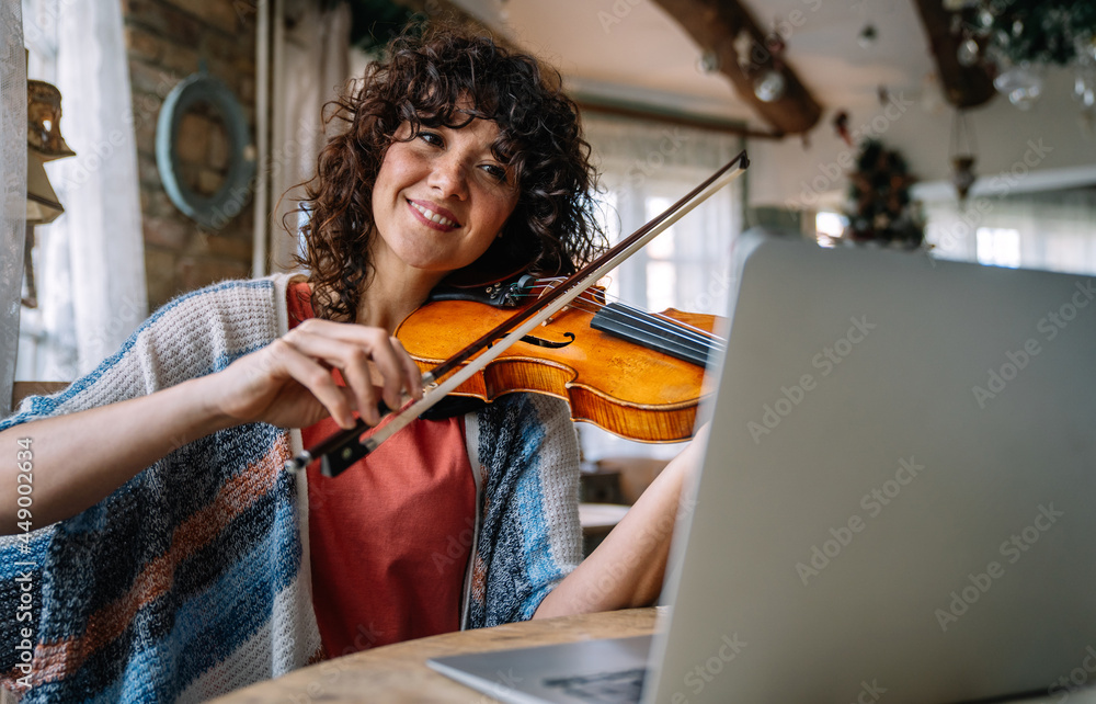 Woman Student Learns To Play The Violin Online Using A Laptop Stock woman-student-learns-to-play-the-violin-online-using-a-laptop-stock