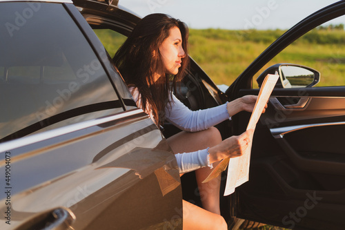Young woman travel the roads in a car, look at the map Vacation concept photo