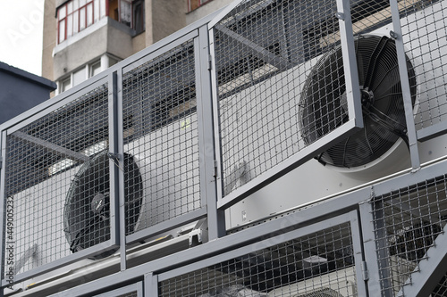 Air conditioning units on the facade of the shop, installed in the metal cage for safety. Selective focus.
