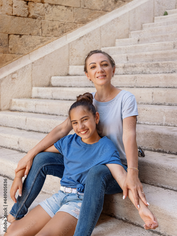 Mother and daughter sitting on the stone stairs outdoor Mother and daughter sitting on the stone stairs outdoor