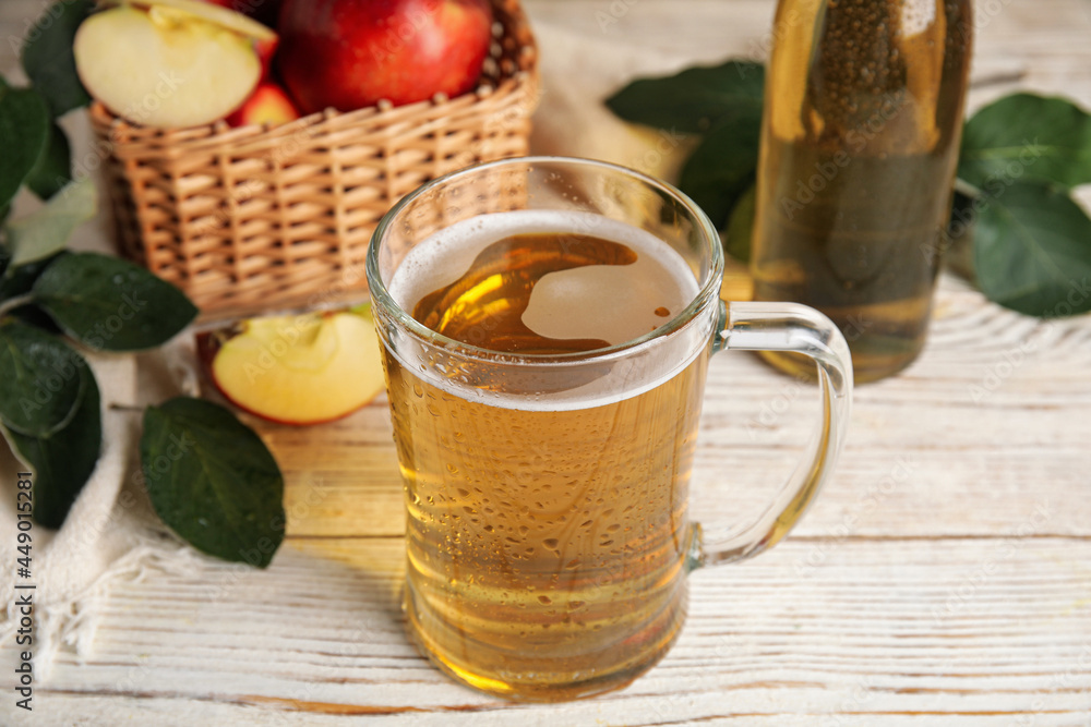 Delicious apple cider in glass mug on white wooden table Delicious apple cider in glass mug on white wooden table