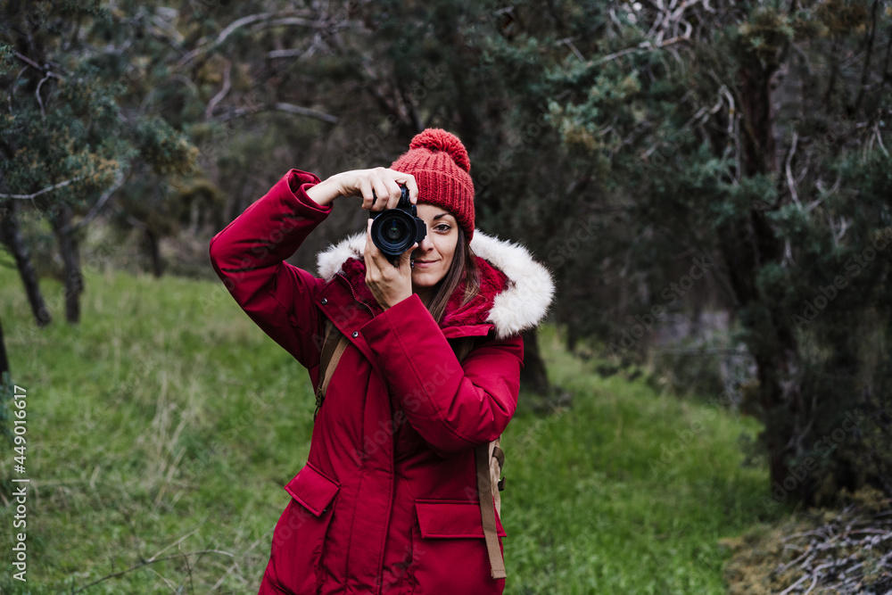 backpacker caucasian woman taking picture with camera in forest during winter or autumn season. Lifestyle and nature backpacker caucasian woman taking picture with camera in forest during winter or autumn season. Lifestyle and nature