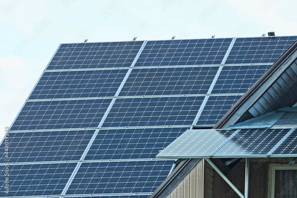 Fototapeta premium gray solar panels on the roof of a private house against the sky