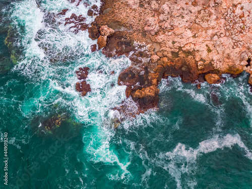 Aerial view of rocky coastline and crashing waves