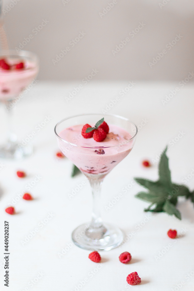 Delicious dessert, cheesecake with fresh raspberries and butter cream mousse in glass on a white table. Copy space Delicious dessert, cheesecake with fresh raspberries and butter cream mousse in glass on a white table. Copy space
