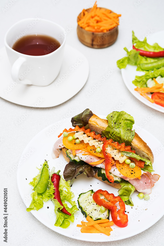 Banh mi sandwiches with various stuffing and cup of tea. Traditional vietnamese breakfast. Trendy still life in light colors. Banh mi sandwiches with various stuffing and cup of tea. Traditional vietnamese breakfast. Trendy still life in light colors.