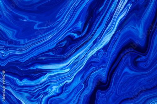 Fluid art texture. Abstract backdrop with mixing paint effect. Liquid acrylic picture that flows and splashes. Classic blue color of the year 2020. Blue  white and indigo overflowing colors.