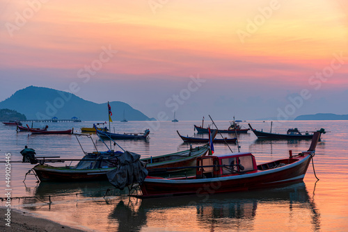 Beautiful sunrise scenery with fishing boats at Rawai Beach in Phuket Island, Thailand.