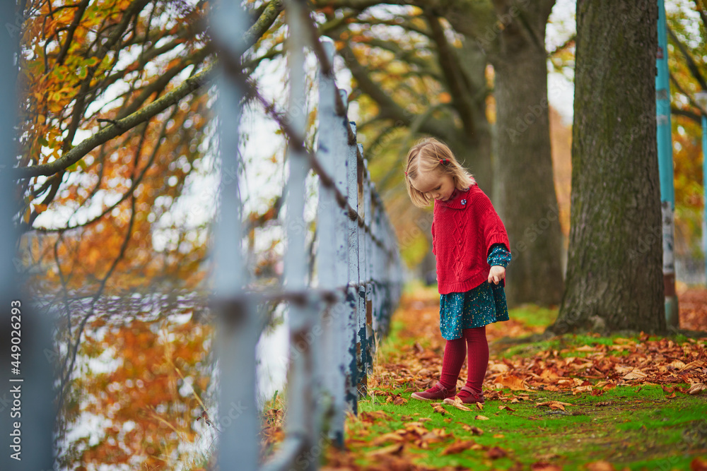 Adorable toddler girl playing in autumn park in Paris, France Adorable toddler girl playing in autumn park in Paris, France