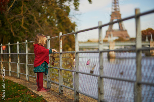 Adorable toddler girl playing in autumn park