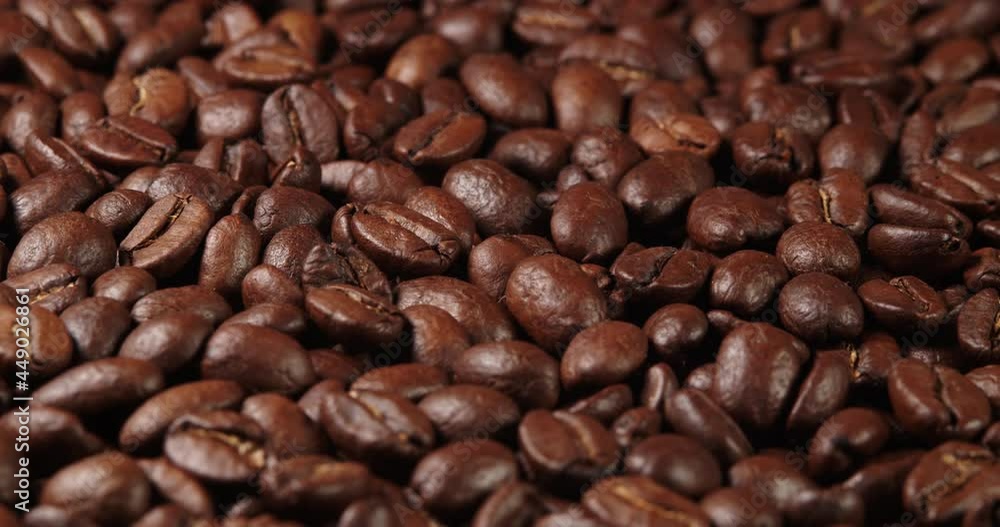 Roasted coffee beans dolly shot. Aromatic coffee beans move slowly. Slide slow motion close-up of whole roasted coffee beans. Roasted coffee beans dolly shot. Aromatic coffee beans move slowly. Slide slow motion close-up of whole roasted coffee beans.
