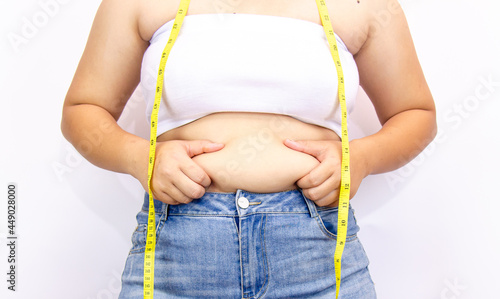 Beautiful fat woman with tape measure She uses her hand to squeeze the excess fat that is isolated on a white background. She wants to lose weight, the concept of surgery and break down fat under the