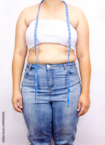 Beautiful fat woman with tape measure She uses her hand to squeeze the excess fat that is isolated on a white background. She wants to lose weight, the concept of surgery and break down fat under the