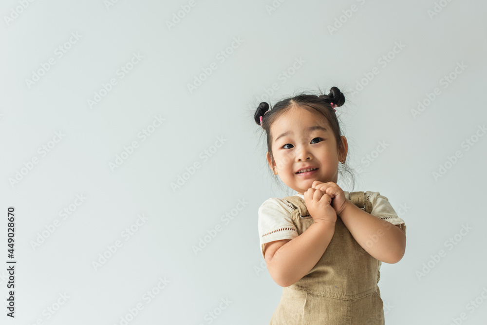 cheerful asian toddler girl smiling isolated on grey cheerful asian toddler girl smiling isolated on grey
