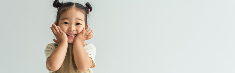 happy asian toddler girl smiling isolated on grey, banner