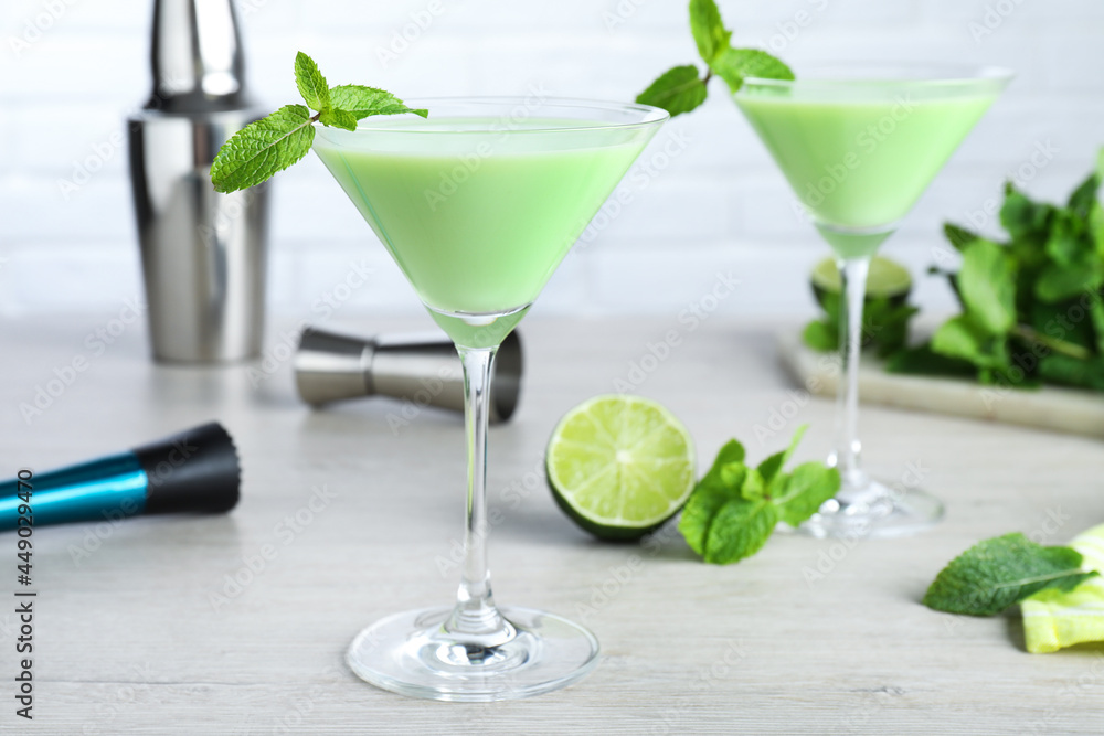 Delicious mint liqueur with green leaves on white wooden table