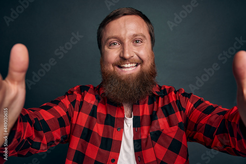 Good-looking romantic bearded man congratulate girlfriend with new job via video-call message, record blog, hands spread sideways holding digital tablet or laptop smiling talking to friend or support