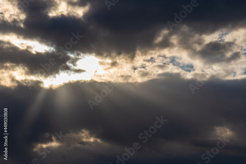 Rays of light shining throug dark clouds.Beautiful dramatic sky with sun rays. © ARVD73