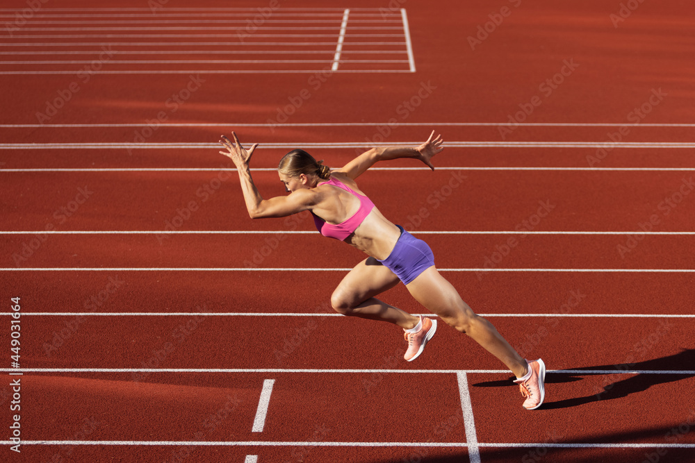 Track-and-field athletics. Young Caucasian woman, professional athlete,  runner training at public stadium, sport court, outdoors. Concept of sport,  achievment, motion. Stock Photo