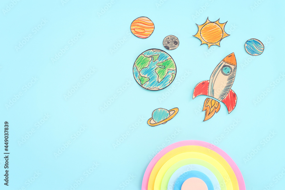Painted rocket and planets over wooden blue background