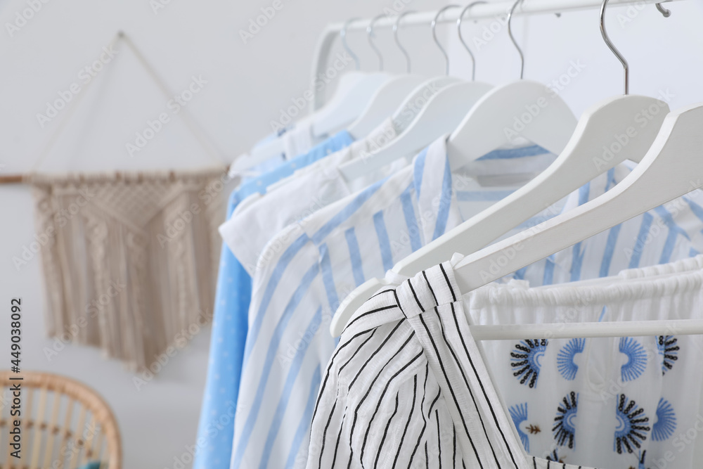 Rack with stylish hanging clothes in dressing room